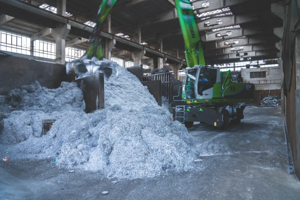 Greifbagger in der Halle an einem Berg Aluminiumspäne